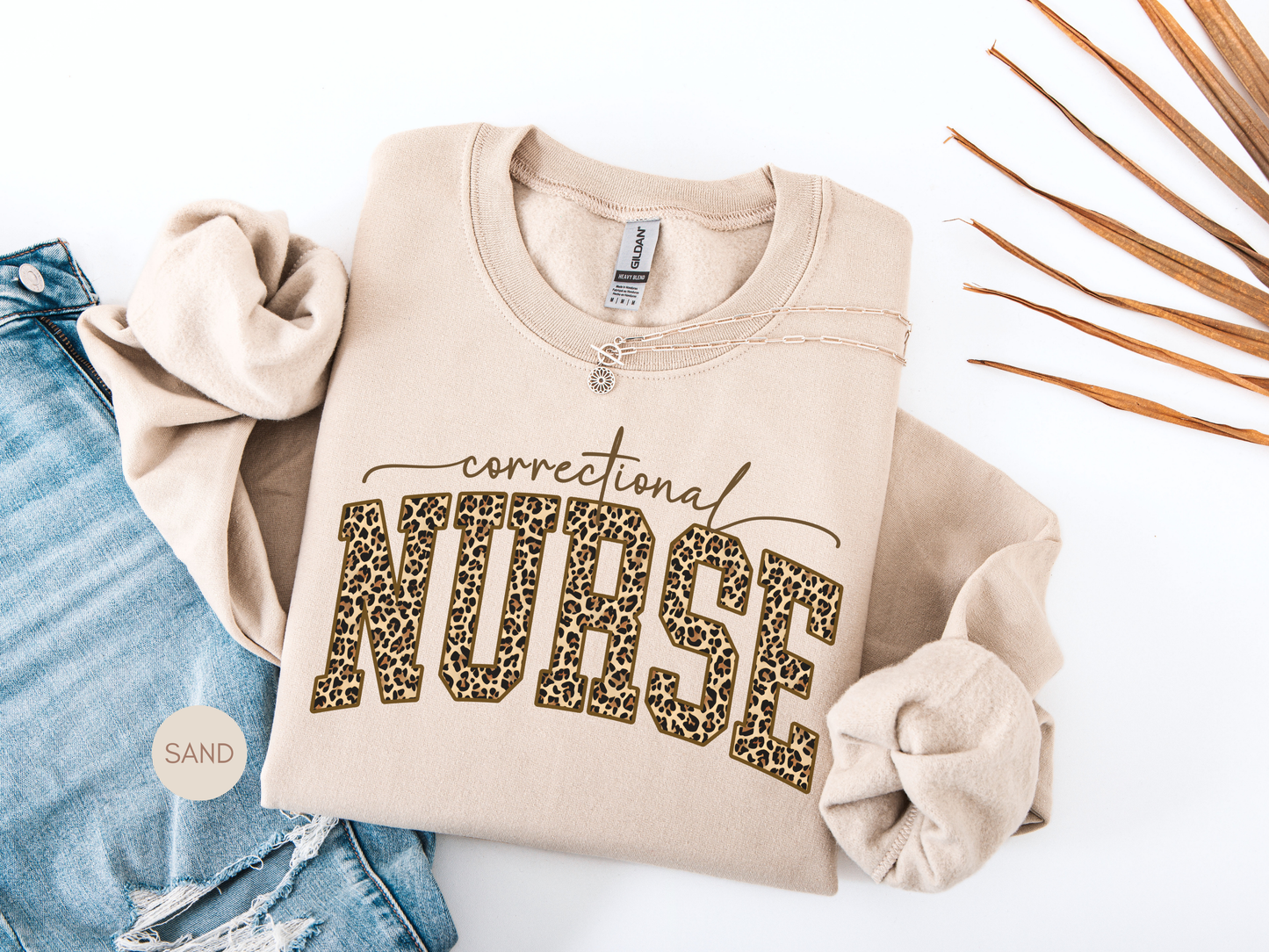 Correctional Nurse leopard print sweatshirt in sand color, cozy crewneck nurse gift laid flat with neutral decor