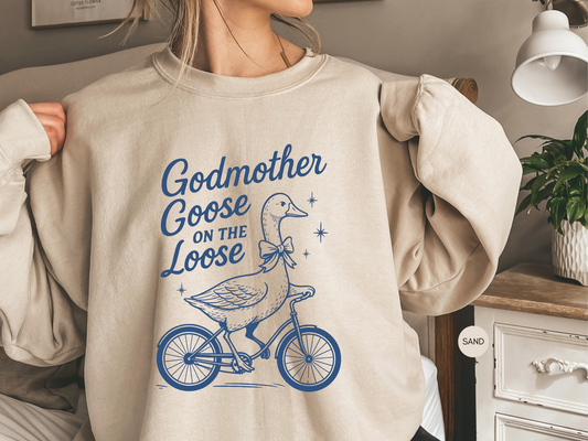 Godmother Goose On The Loose sweatshirt in sand color with vintage blue goose bicycle graphic design