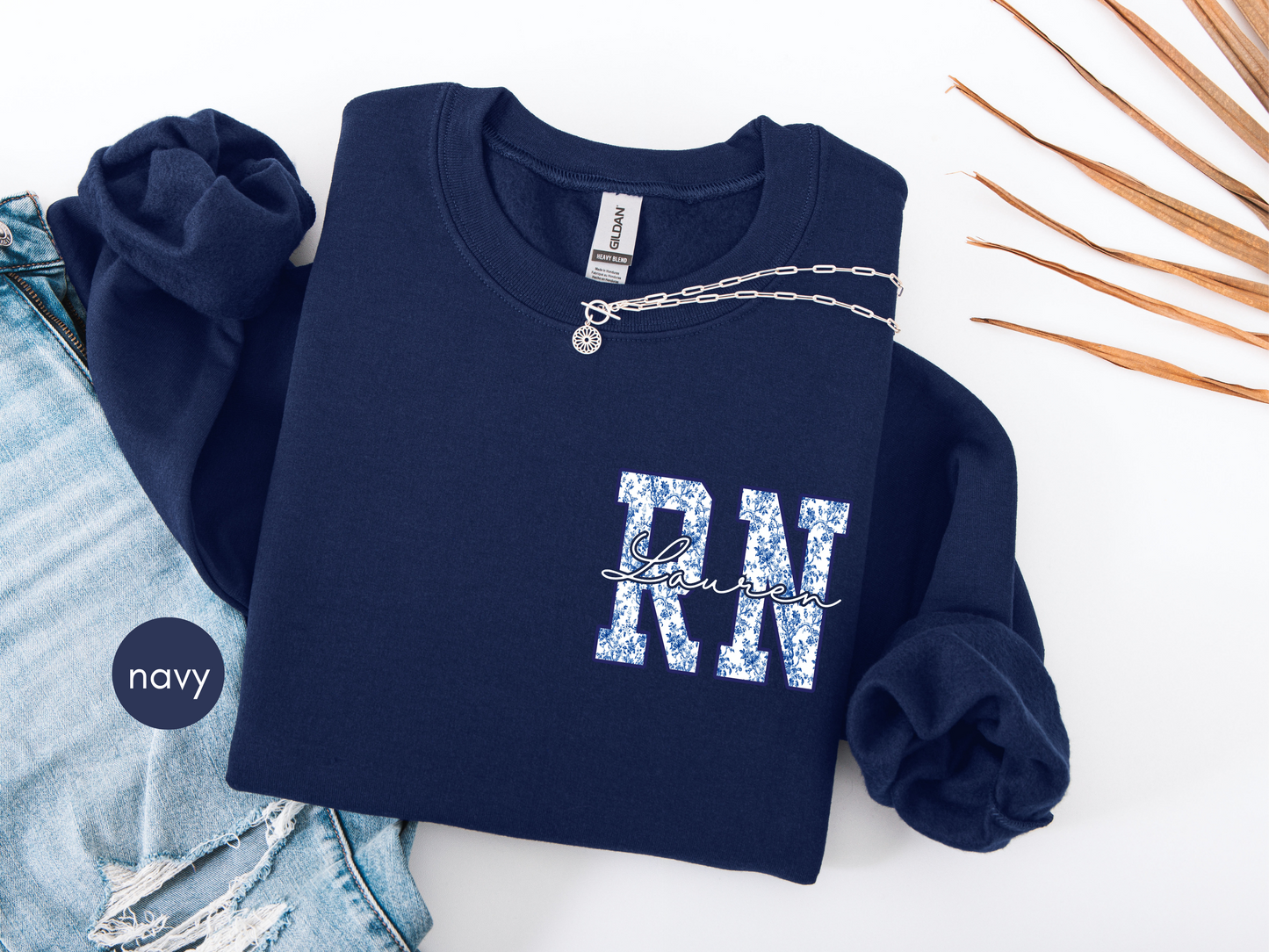Custom RN sweatshirt with blue toile lettering on navy crewneck worn by model
