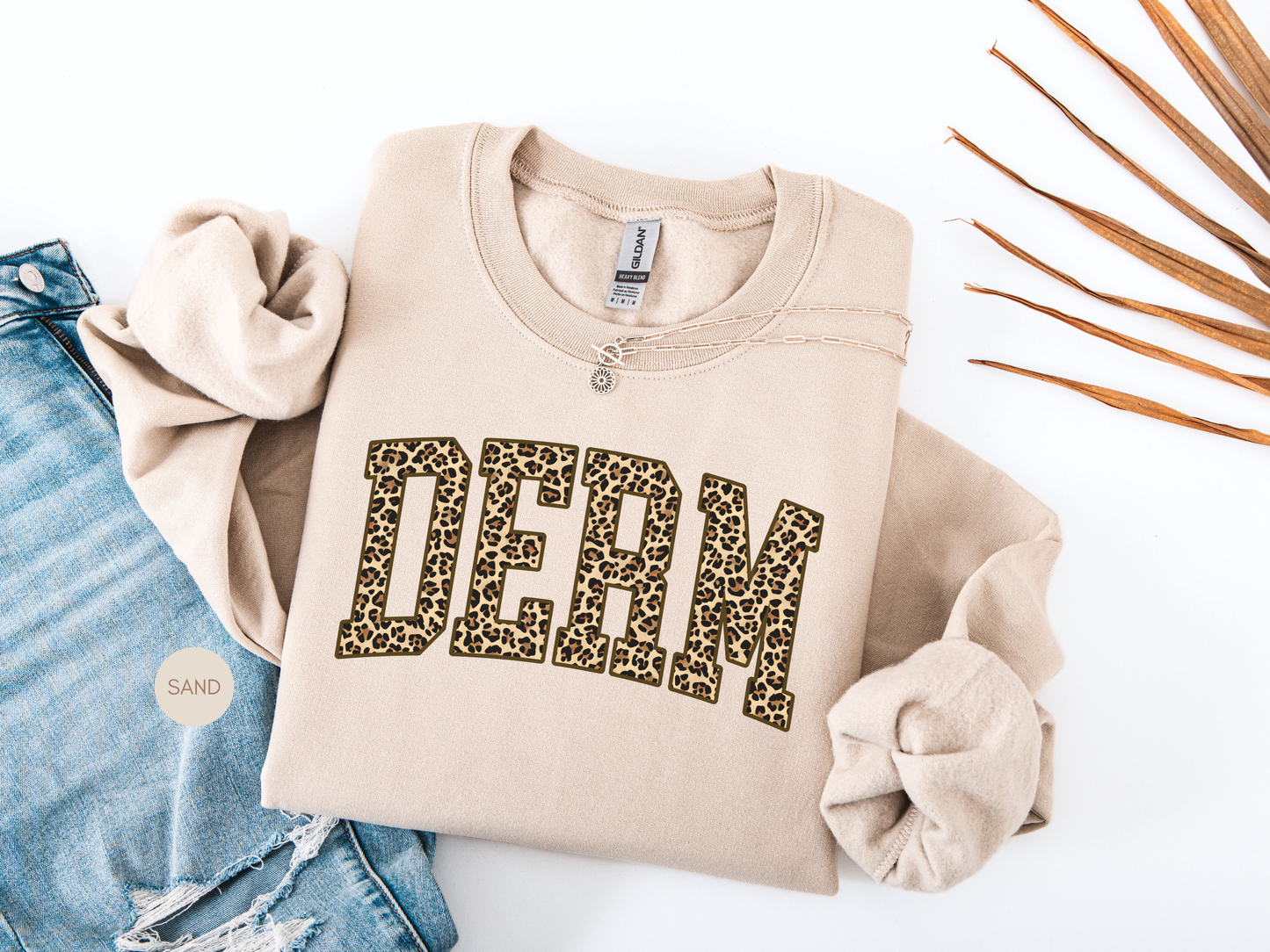 Beige DERM leopard print sweatshirt styled flat lay, perfect gift for dermatology nurse