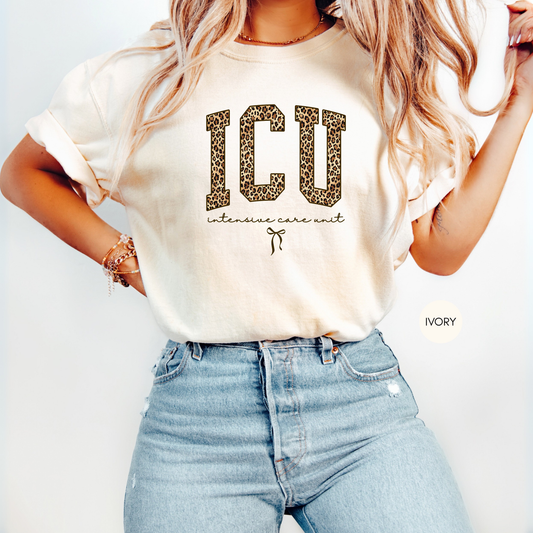 Woman wearing ivory ICU nurse leopard graphic t-shirt styled with jeans, intensive care unit nurse apparel gift idea.