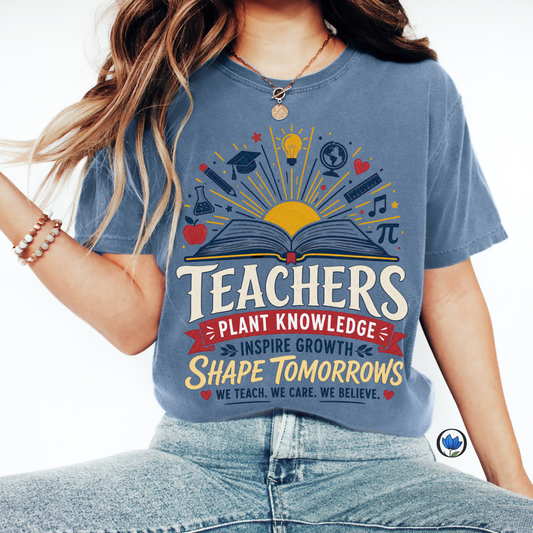 Woman wearing a Blue Jean Comfort Colors® Teacher graphic T-shirt featuring an open book with educational icons and the inspirational quote "Teachers Plant Knowledge, Inspire Growth, Shape Tomorrows."